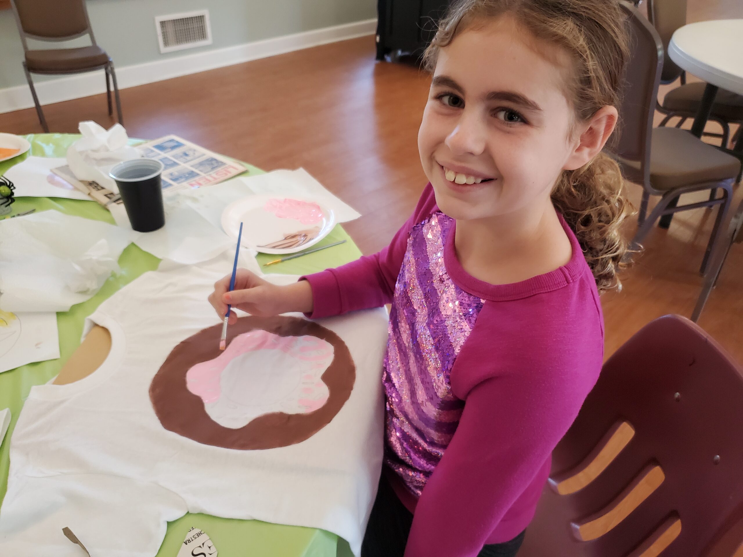 Young artist painting a project at a class